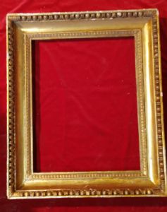 Cornice in legno dorato ed intagliato con motivo ad ovuli e fogliette d'acanto.Sagoma a gola Impero luce cm.49 x 63 I° 800
